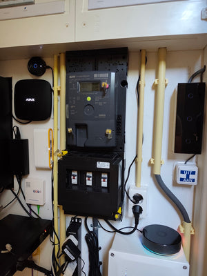 Meterkast met compacte Livolo smart home gateway naast Homey en Ajax apparatuur